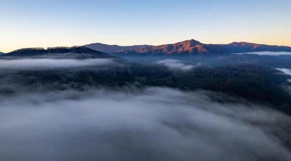 A mountainous landscape with a prominent peak and forested valleys. - Contrast Cove Dome in Smoky Mountains - GlampiTiN
(Hartford)