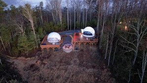 Een afgelegen hutje met twee koepelvormige constructies, omringd door dicht bos.