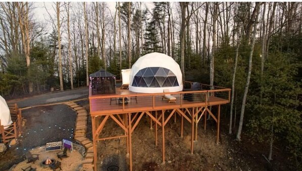A geodesic dome structure with a wooden deck and a fire pit area. - Contrast Cove Dome in Smoky Mountains - GlampiTiN

 (Hartford)