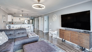 A modern living room with a sectional sofa, a flat-screen TV, and a wooden entertainment unit. - Lakefront Retreat w/ Community Pool in Osage Beach (Osage Beach)