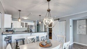 A modern kitchen with white cabinets, a central island, and pendant lighting. - Lakefront Retreat w/ Community Pool in Osage Beach (Osage Beach)