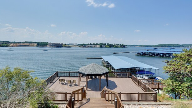 A wooden deck with a gazebo, overlooking a calm body of water with docks and boats. - Lakefront Retreat w/ Community Pool in Osage Beach (Osage Beach)