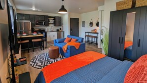 Un apartamento moderno con cocina, comedor y sala de estar con sofá y reposapiés.