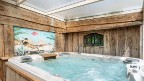 A hot tub with wooden walls and a mural of a tropical scene.