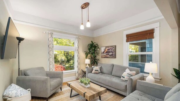 A living room with two grey sofas, a wooden coffee table, and a floor lamp. - Paradise Haven-95 walk score-Dedicated Workspaces (Portland)