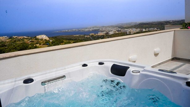 Ein Whirlpool auf einem Balkon mit Blick auf die Stadt.