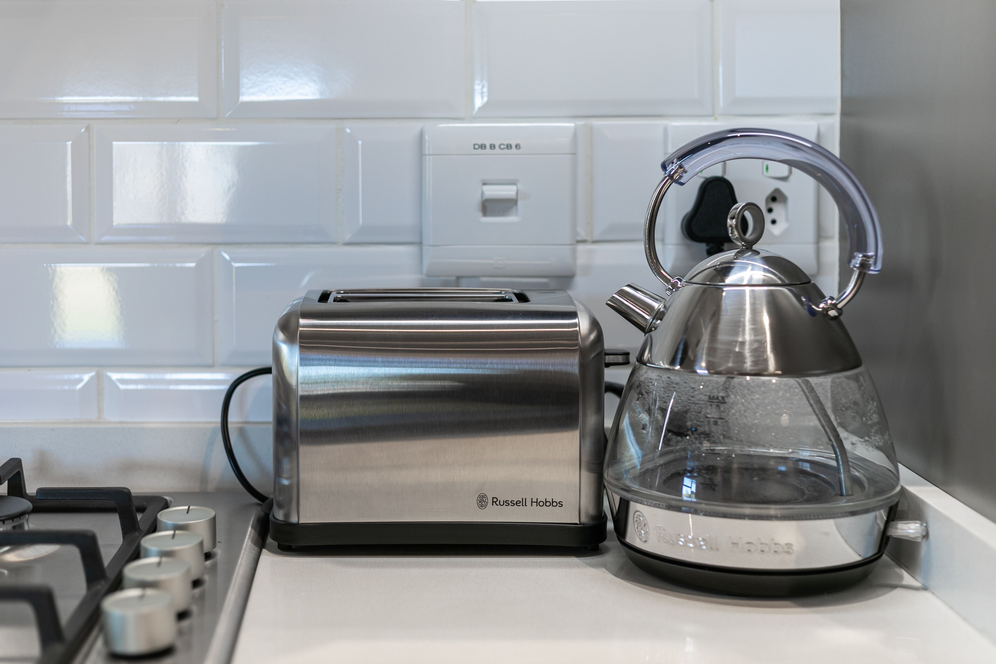A kitchen with a toaster and a kettle on the counter.