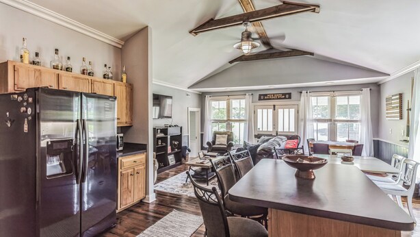 A modern kitchen with a large island, wooden cabinets, and a stainless steel refrigerator. - New Hope Bourbon Stop- historic home, peaceful spot in heart of Bourbon country (New Hope)