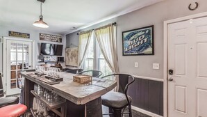 A kitchen with a bar area, a television, and a door with a sign. - New Hope Bourbon Stop- historic home, peaceful spot in heart of Bourbon country (New Hope)