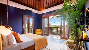 Un dormitorio con cama, una silla, un ventanal grande y una planta.