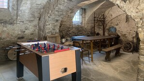 A rustic room with a foosball table, a wooden bench, and a stone wall. - Censo Guest House : are you ready for your next adventure? (Marsaglia)