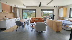 A modern living space with a kitchen, dining area, and a bedroom.