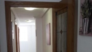 A hallway with wooden doors and a tiled floor. - El Campello Deborah. à 10 Minutes à Pied de la Plage et 5 Minutes du Centre (El Campello)