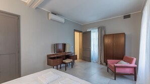 Una habitación de hotel con cama, escritorio, silla y armario.