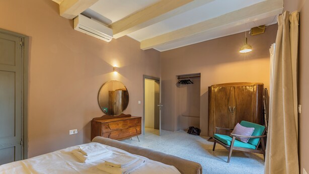 A bedroom with a bed, dresser, mirror, and a chair. - Mid-Century Retro Suite (Floriana)