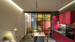 Un espacio habitable compacto con kitchenette, comedor y dormitorio.