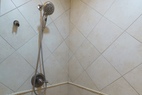 Ducha con cabezal de mano y grifería empotrada.