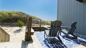 A deck with two Adirondack chairs and a wooden bench overlooking a beach. - Atlantic Beach Getaway Spacious 3-Level Condo: Walk to the Beach & Pool (Atlantic Beach)