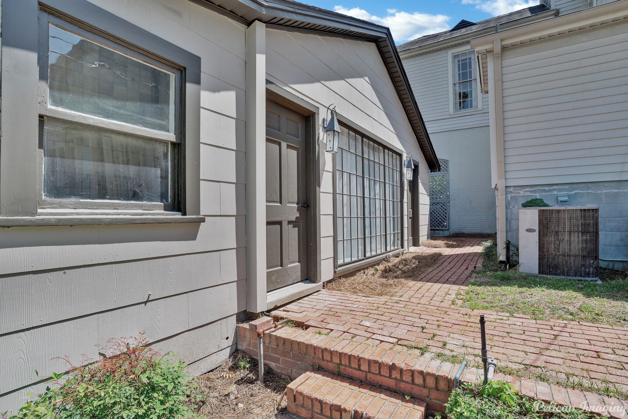 A residential building with a brick pathway leading to a garage door.