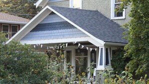 Ein zweistöckiges Haus mit Satteldach und einer Veranda.