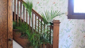 Eine Holztreppe mit einem Blumentopf am Fuß.