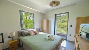 Un dormitorio con cama, mesita de noche, lámpara, armario y escritorio con ordenador.