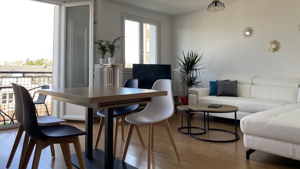 A modern living room with a dining area, white sofa, and a large window. - Chez Julien,lumineux-accueillant-spasieux (Troyes)