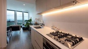 A modern kitchen with a large island, built-in oven, and a gas stove. - Stunning 1-bed Unit in 56th Floor in Southbank! (Southbank)