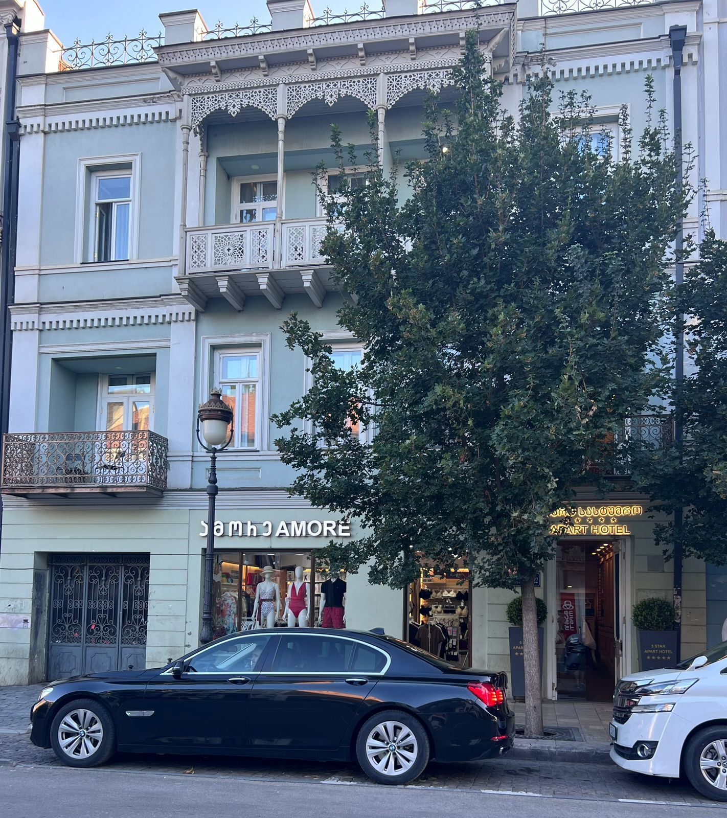 Ein Gebäude mit einem Boutique-Hotel namens 'Samantha Amore' im Erdgeschoss, vor dem ein großer Baum steht.