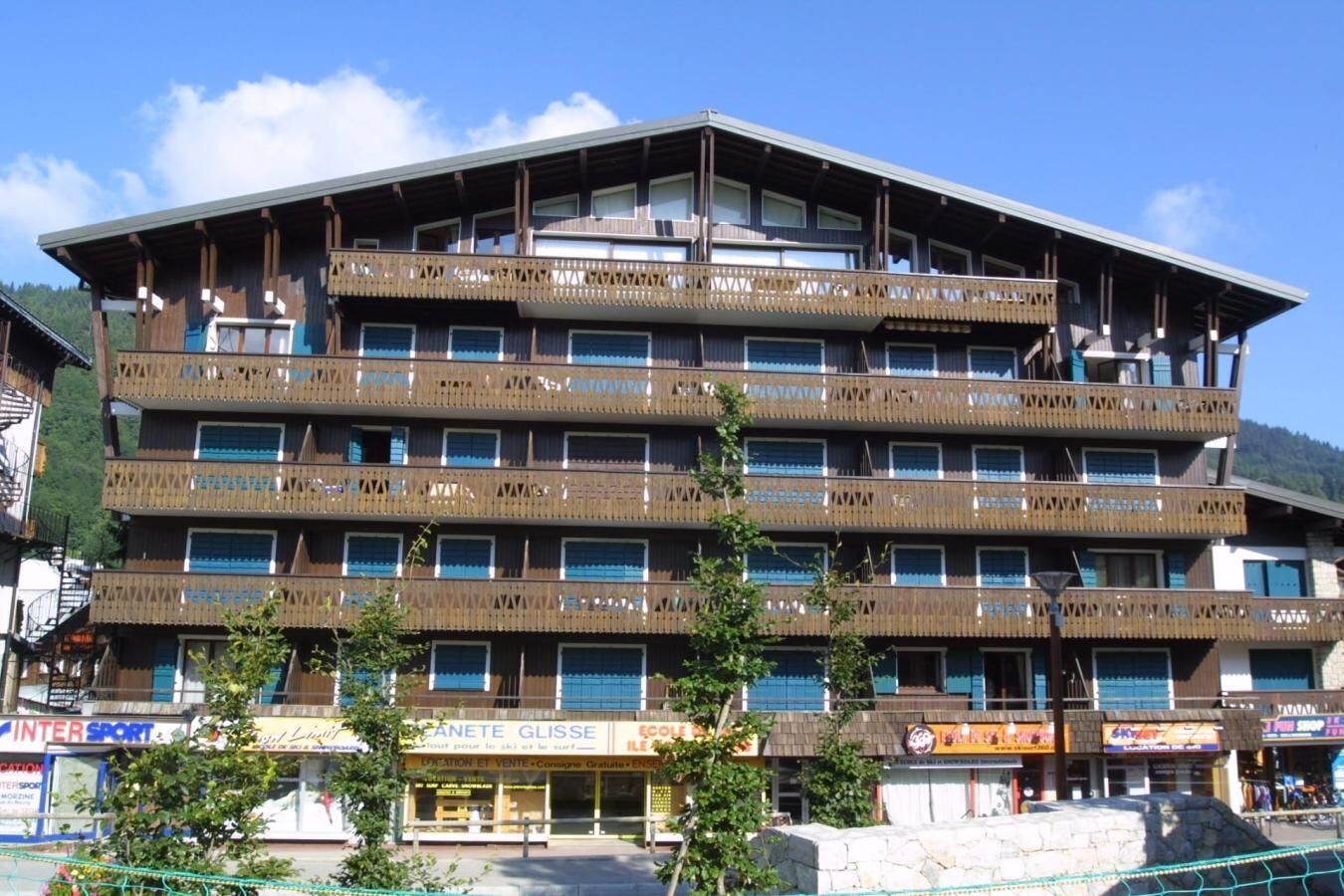 A multi-story hotel with balconies, a ski shop, and a restaurant.