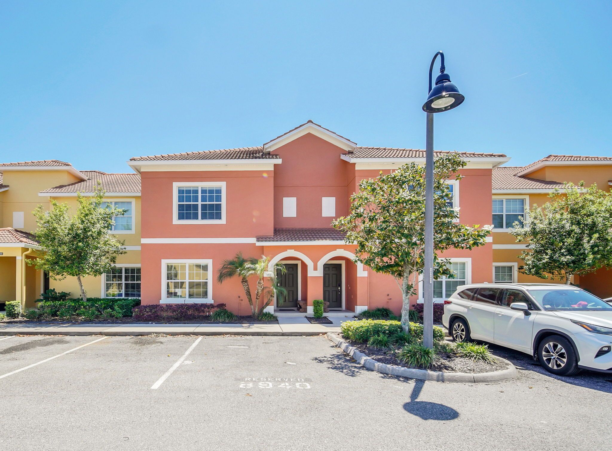 A multi-story residential building with a parking lot in front.