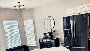 A modern kitchen with a central island, black chairs, a refrigerator, and a coffee station. - 4 bedrooms+Outdoor gazebo+Garage+office (Tulsa)