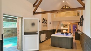 A modern interior with a hot tub, a door leading to an outdoor area, and a loft bedroom. - Inédit! Spa, Piscine, Salle de Jeux (La Poterie-Cap-d'Antifer)