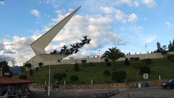Una plaza pública con una gran escultura, escalones y una zona de café.
