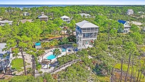 Une propriété située sur la côte, avec une grande maison dotée d’un balcon imposant, d’une piscine et d’une vue sur l’océan.