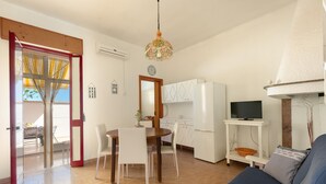 A compact living space with a dining area, kitchenette, and a sofa.