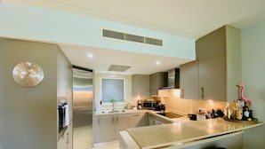 Una cocina moderna con una isla central, electrodomésticos de acero inoxidable y un ventanal.