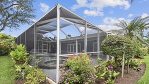 A greenhouse with a transparent roof, surrounded by various plants and flowers. - Private house with heated pool in the custom tropical garden.
 (Naples)