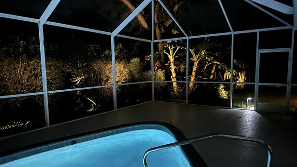 A pool area with a glass enclosure, surrounded by plants and trees. - Private house with heated pool in the custom tropical garden.
 (Naples)