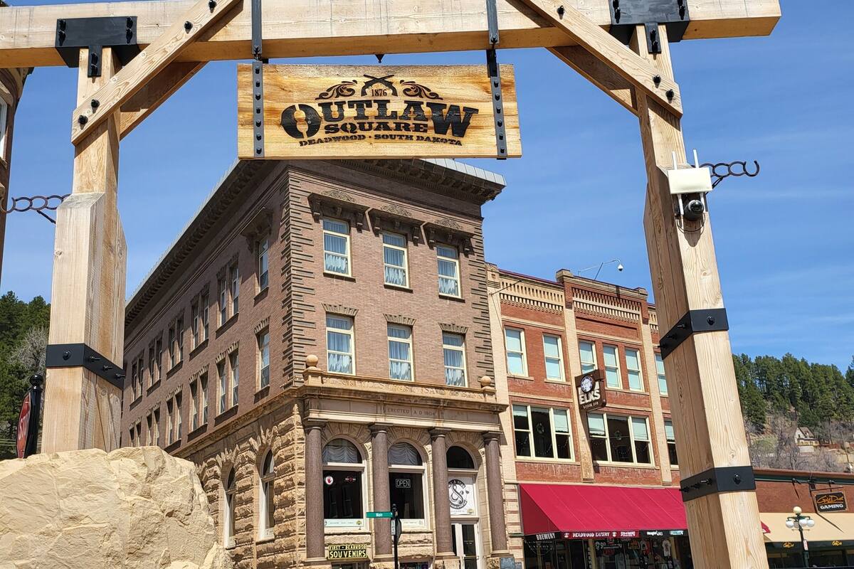 Un bâtiment historique doté d’une arche en bois sur laquelle on peut lire « OUTLAW SQUARE » et d’une enseigne indiquant « ELKS ».
