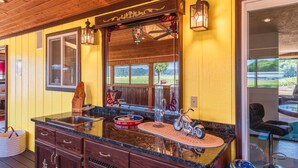 A kitchen with a large island, wooden cabinets, and a view of the outdoors. - Close to Coquille River, Bandon Dunes, centrally located in the county -hot tub! (Coquille)
