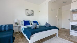 A modern bedroom with a bed, bedside table, and a small kitchenette. - Sea view accommodation 300 metres to the beach (Dramalj)