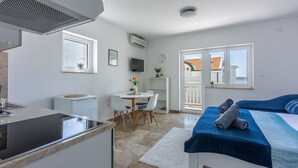 A modern hotel room with a kitchenette, a dining area, a bed with towels, and a balcony with a view. - Sea view accommodation 300 metres to the beach (Dramalj)