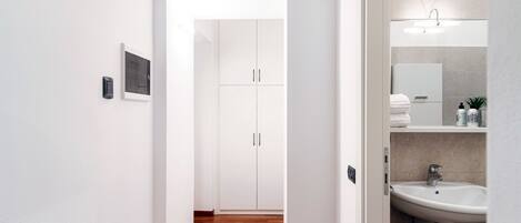 Un baño moderno con un lavamanos, espejo y muebles blancos.