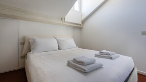 A bedroom with a bed, pillows, and a window. - Italianway Comfort - Vigevano 7 (Milano)