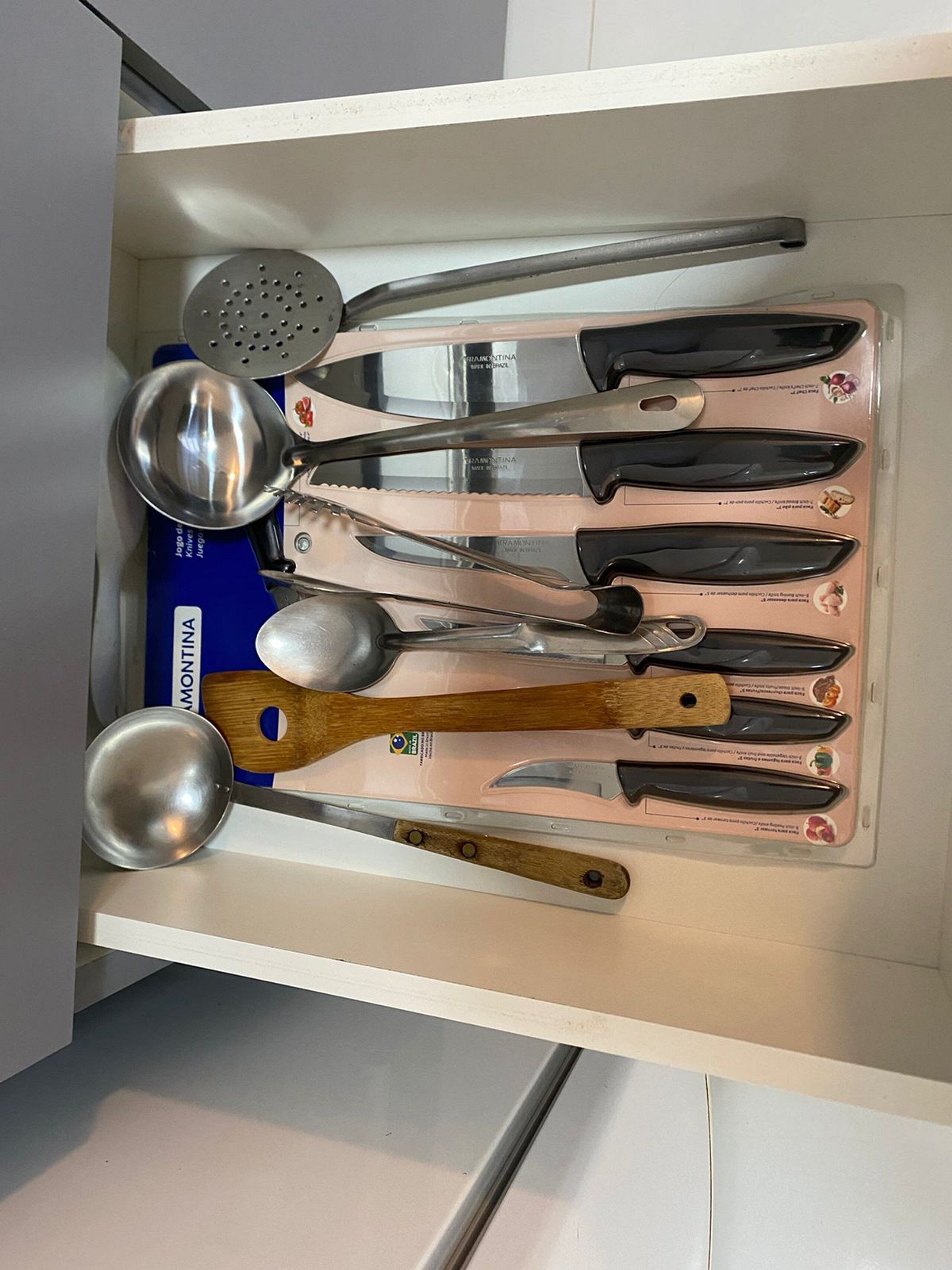 A drawer containing various kitchen utensils including spoons, spatulas, and a ladle.
