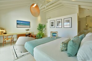 Un dormitorio con cama, escritorio, silla, lámpara colgante y zona de ducha.