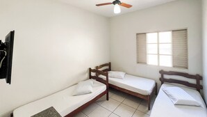 A small, clean room with two single beds, a ceiling fan, and a window with shutters. - Elite Economy Hotel (Para de Minas)