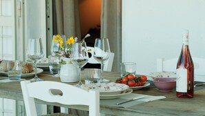 Una tavola da pranzo apparecchiata con bicchieri da vino, piatti e una bottiglia di vino.