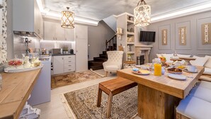 Una cocina moderna con comedor, que incluye una mesa de madera, sillas y una araña.